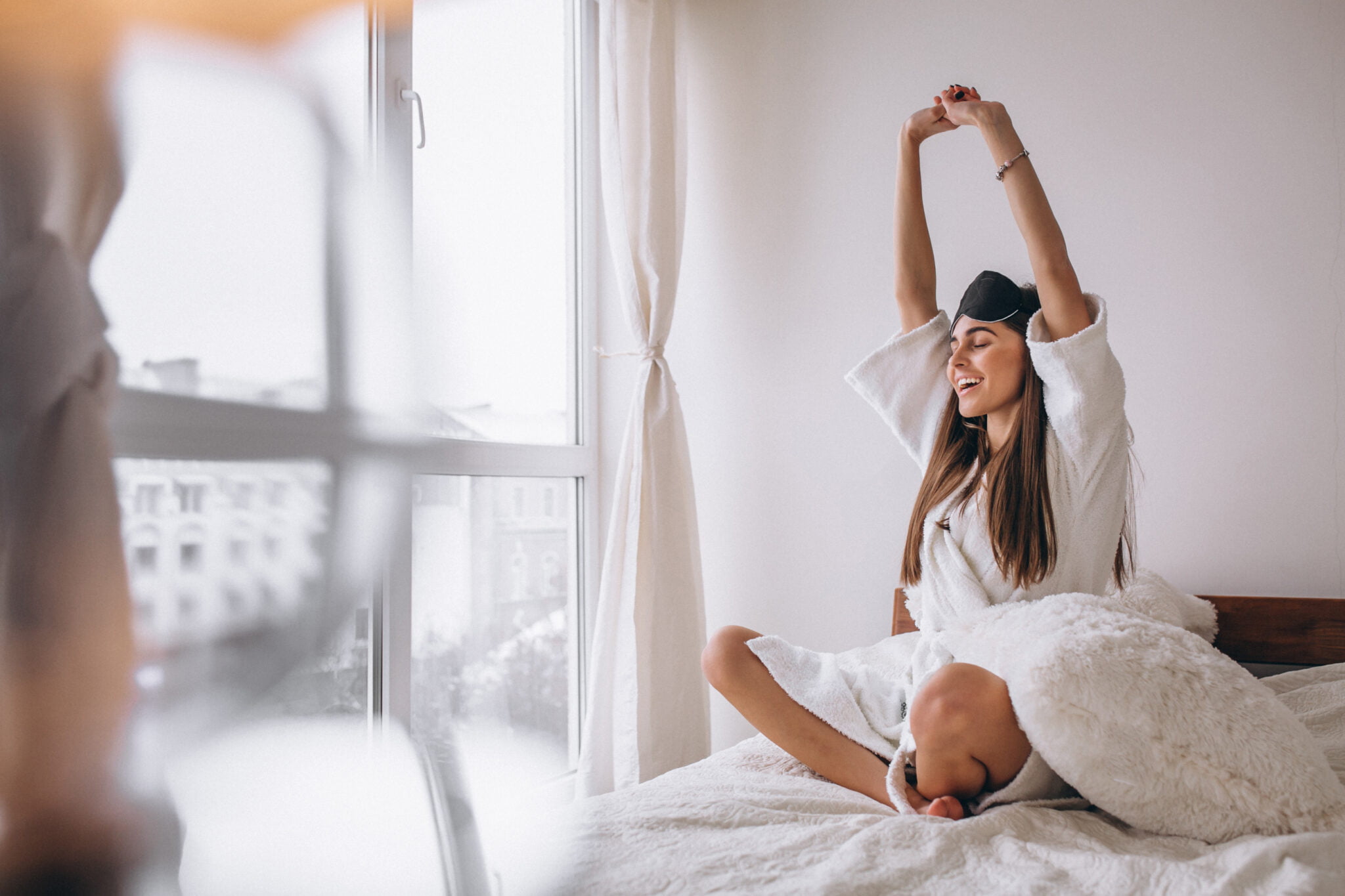 mujer en la cama estirando los brazos